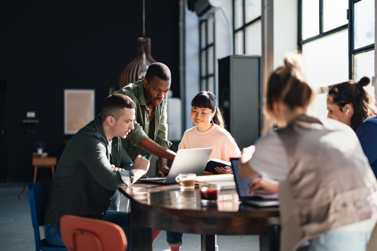 Young professionals or students collaborating in a bright, contemporary co-working environment, displaying teamwork and productivity.